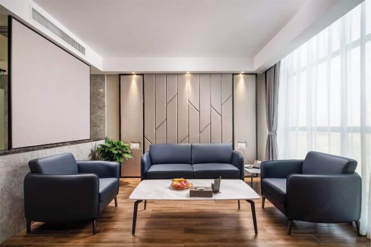 Ein modernes Wohnzimmer mit einer Sofagarnitur, einem Couchtisch und einer Pflanze.