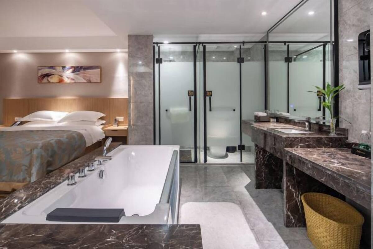 Ein modernes Badezimmer mit einer großzügigen Badewanne, einer separaten Duschkabine und einem Waschtisch mit Spiegel.