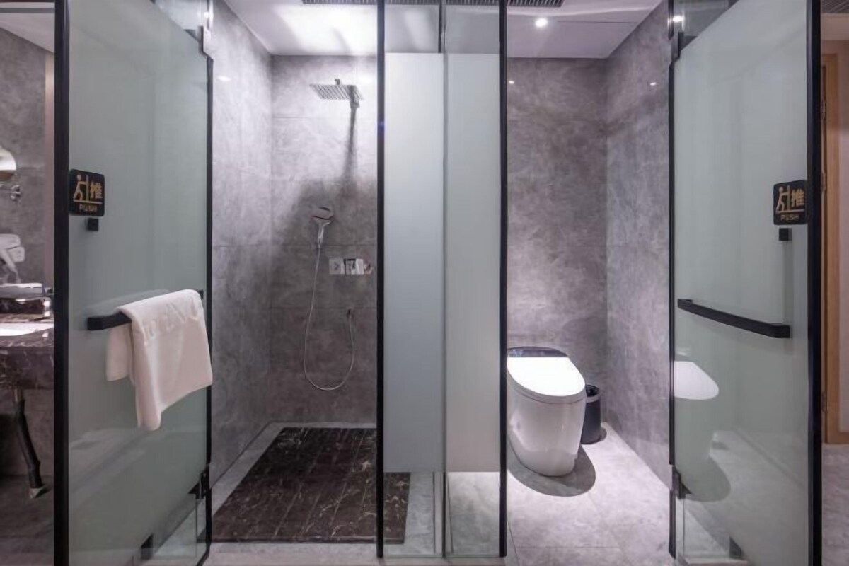 Et moderne badeværelse med bruseniche, toilet og vask.