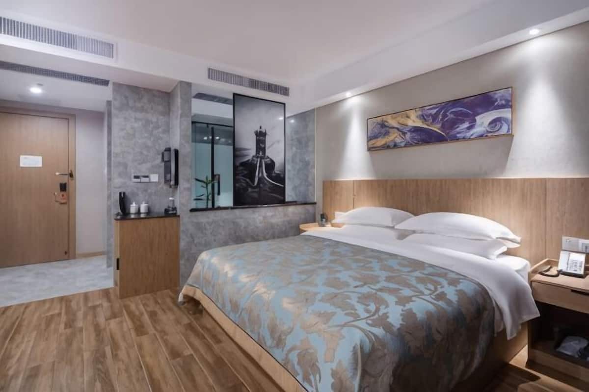 Ein Hotelzimmer mit Bett, Nachttisch und Spiegel.