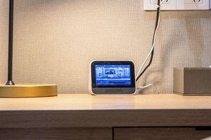 A desk with a laptop, a lamp, and a power outlet.