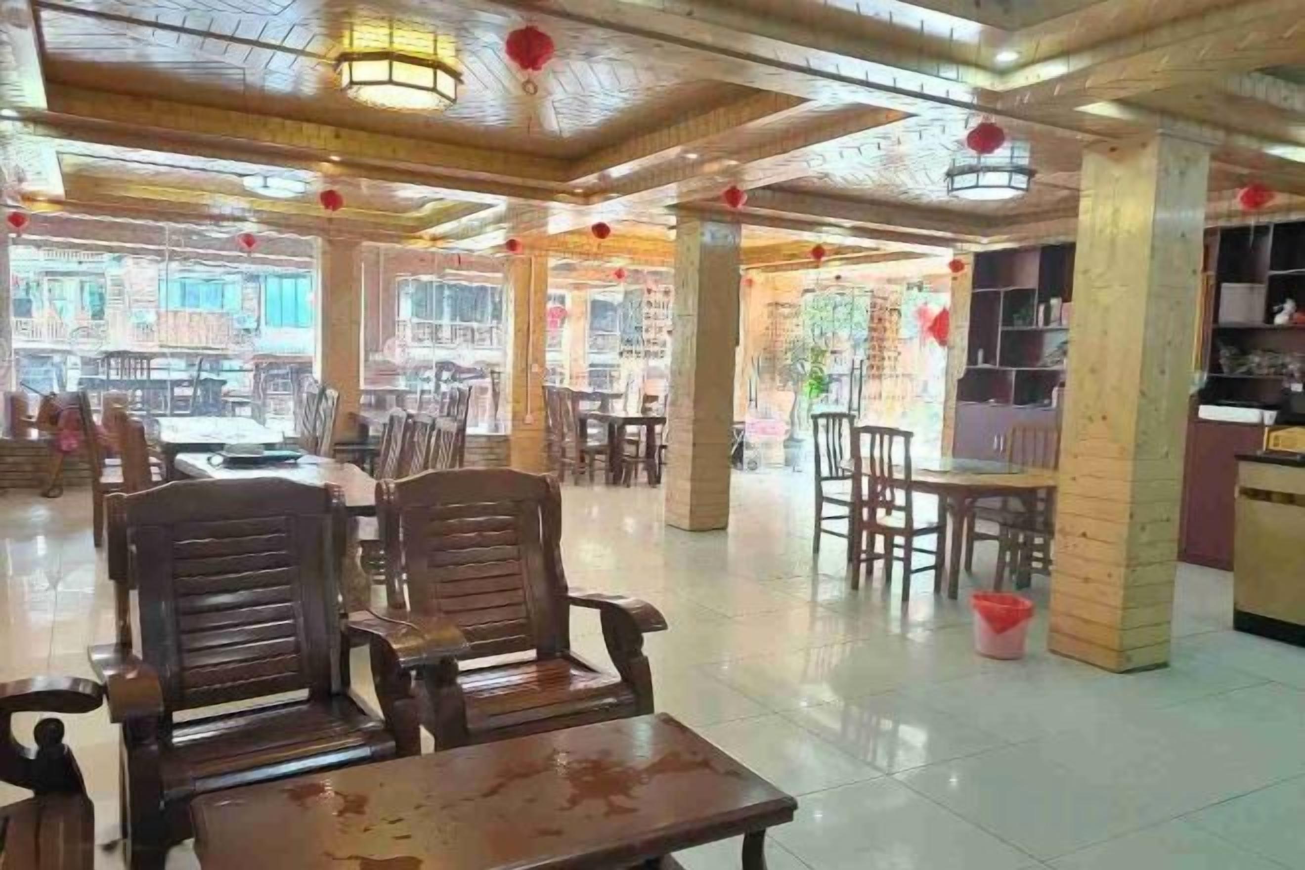 Un restaurant avec des meubles en bois, un sol carrelé et des lanternes rouges.