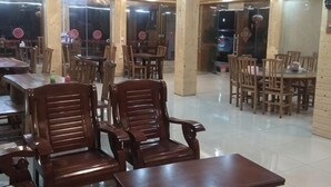 A dining area with wooden tables and chairs, large windows, and a tiled floor. - Longji Terrace Chunyuge Inn (Longsheng)