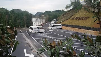 A parking lot with multiple white buses parked in designated spaces.