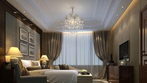 A modern hotel room with a large bed, a sofa, a TV, and a chandelier. - Donghe Hotel (Shuangbai)