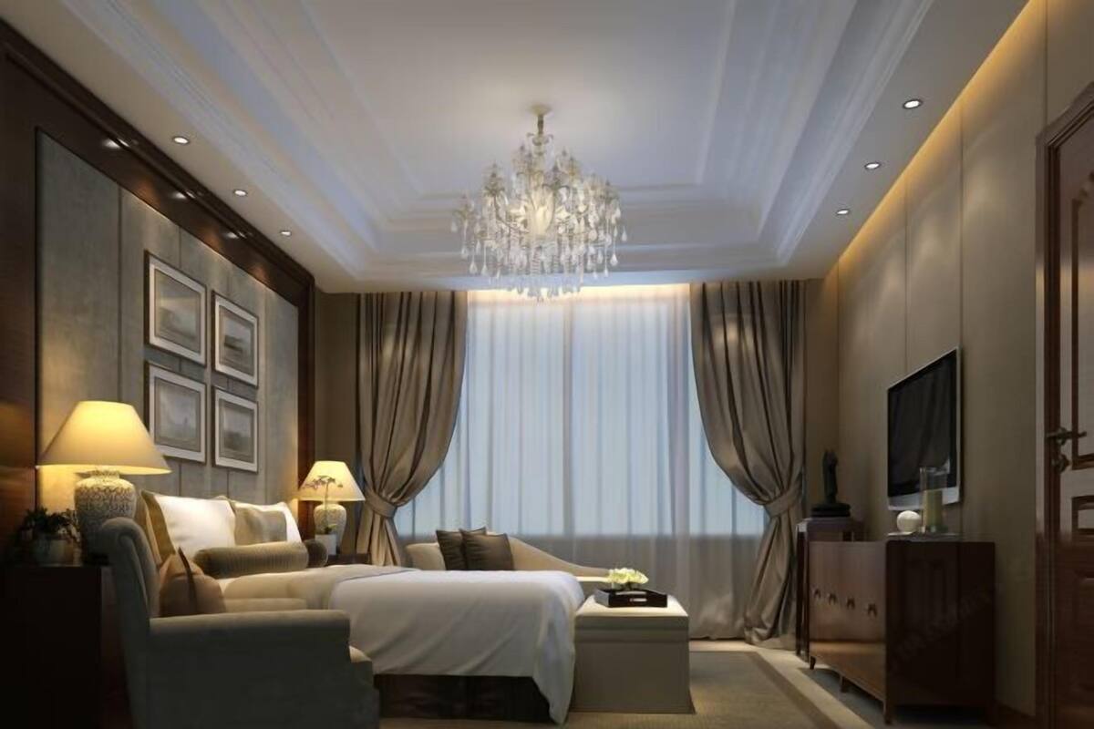 Une chambre d’hôtel moderne avec un grand lit, un canapé, une télévision et un lustre.