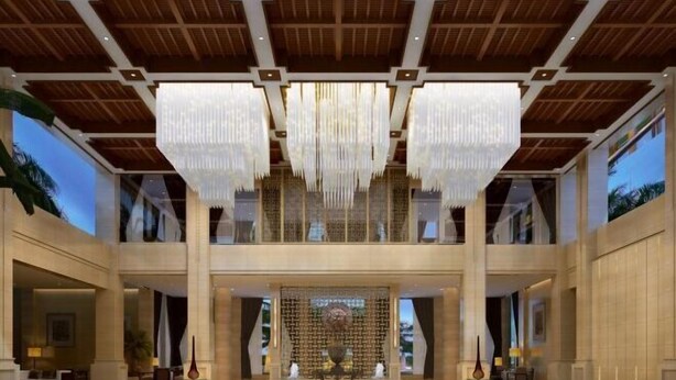 A spacious lobby with a high ceiling, large chandeliers, and a central decorative wall. - Donghe Hotel (Shuangbai)