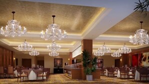 A spacious hotel lobby with multiple chandeliers, a reception desk, and a patterned carpet. - Donghe Hotel (Shuangbai)