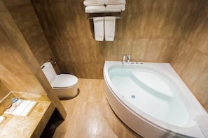 Un baño con bañera, inodoro y toallero.