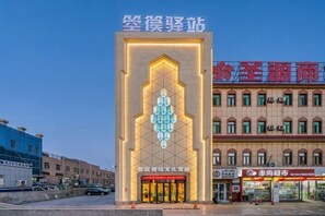 Un edificio con un ingresso importante e un cartello sopra.