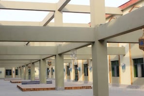 A spacious indoor area with a high ceiling and multiple columns.