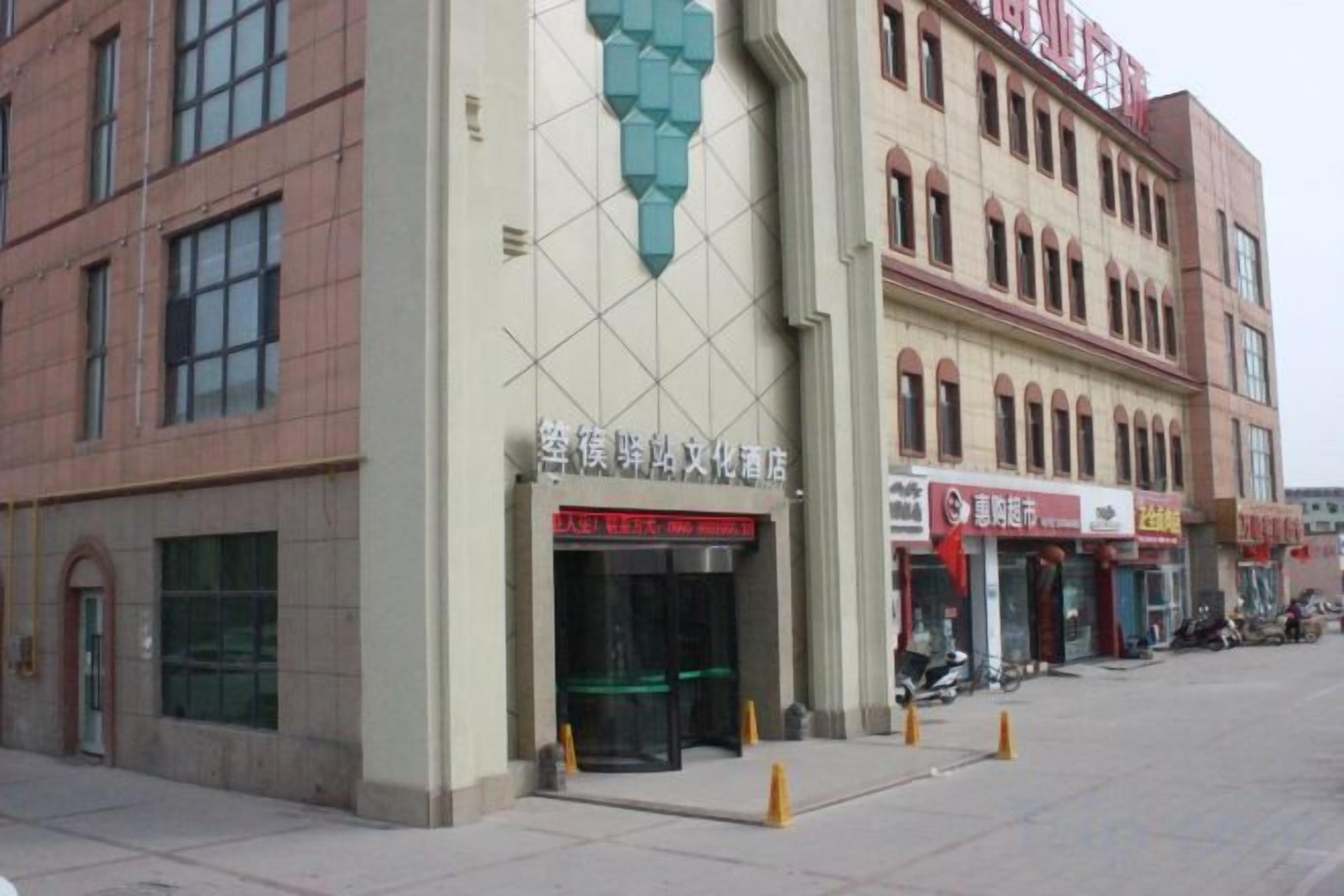 A building with a large entrance, multiple windows, and a sign with Chinese characters.