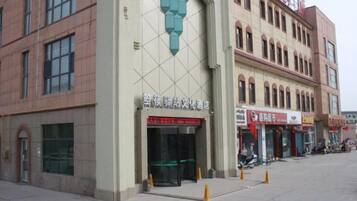 A building with a large entrance, multiple windows, and a sign with Chinese characters.