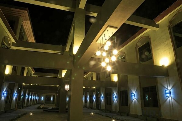 A building with multiple levels, large windows, and a series of lights along the exterior.