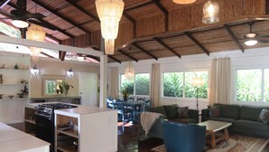 Un amplio salón con cocina, mesa de comedor y un ventanal que proporciona luz natural.
