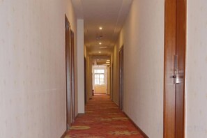 A corridor with doors on both sides, leading to a room with a window. - Renhuai Maoxi Hotel (Renhuai)