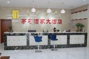 A hotel reception area with a marble counter, two blue bar stools, a reception desk, and a wall-mounted menu board. - Renhuai Maoxi Hotel (Renhuai)