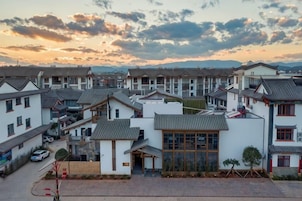 A residential area with multiple houses, some with sloped roofs and others with flat roofs, arranged in a row.