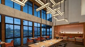 Un comedor espacioso con techos altos, ventanas grandes y modernas luminarias.