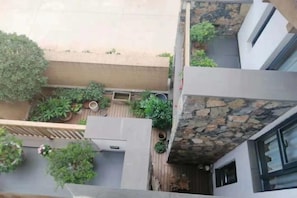 A rooftop terrace with potted plants, a seating area, and a stone wall. - Mouding Lanyun Homestay (Mouding)
