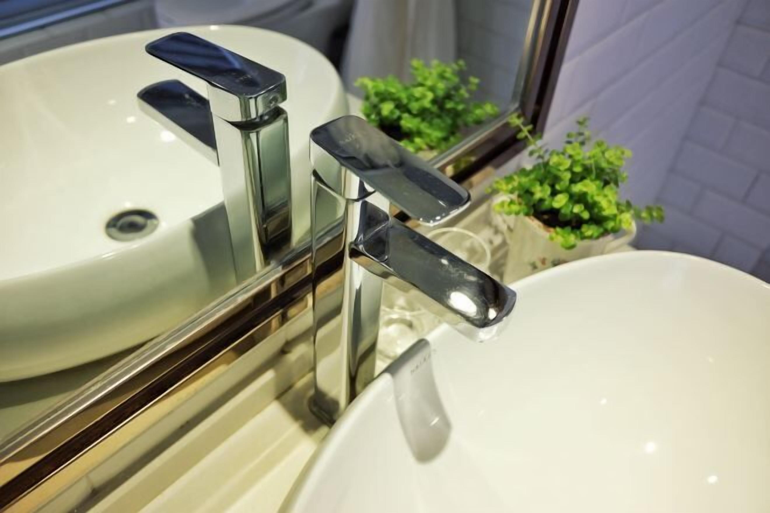 Un baño con dos lavamanos blancos y grifos cromados.
