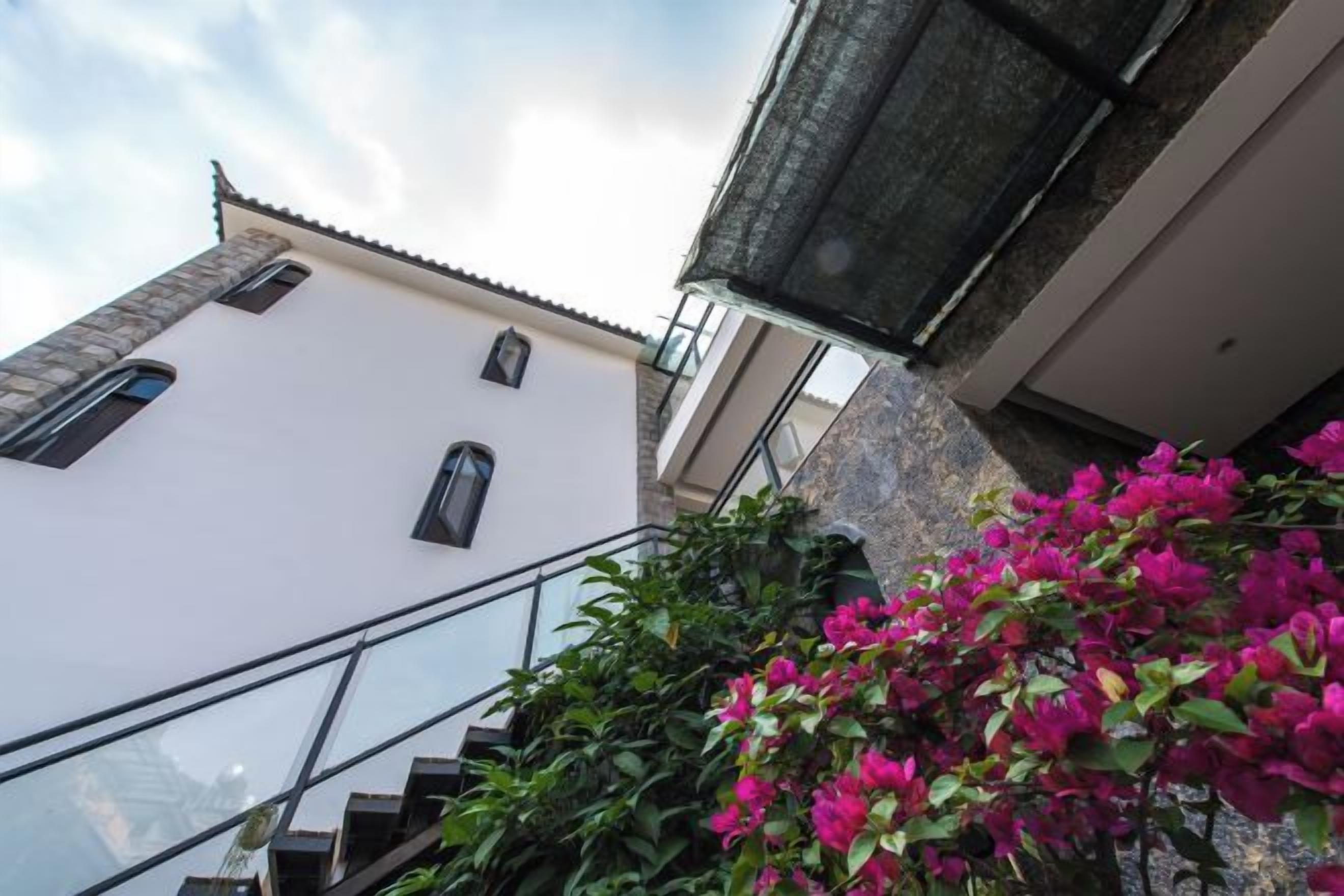 Un edificio con fachada blanca, una ventana visible y una escalera.