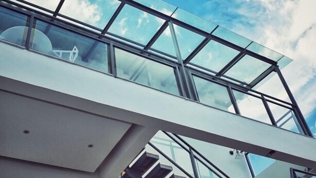 Un edificio moderno con fachada de vidrio y estructura metálica.