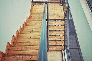 A wooden staircase with a metal handrail.