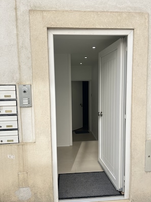 Enter a clean and minimalistic space with a modern design, featuring a white door and a black doormat.