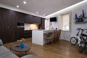 Cozy living space with a central kitchen, flat-screen TV, and seating area.