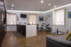 Cozy living space with a central kitchen, flat-screen TV, and comfortable seating area.