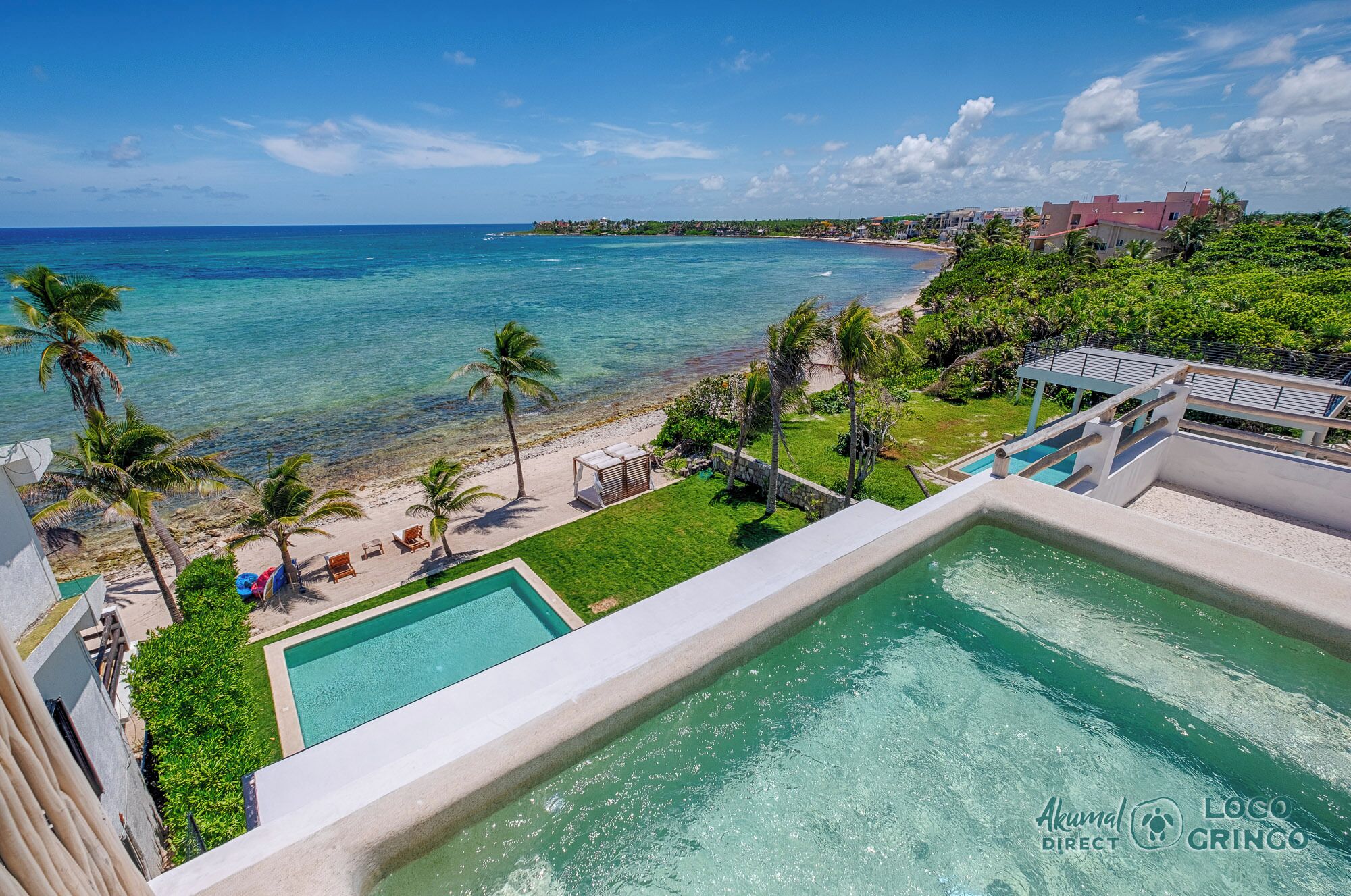 Um resort com piscina, praia e vista para o oceano.