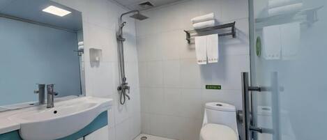 Un baño moderno con lavabo, espejo, ducha, inodoro y cabina de ducha de vidrio.