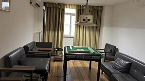 A room with a pool table, two sofas, a ceiling light fixture, and a window with curtains. - Shenzhen Huashang Hotel (Hongling Subway Station KKmall) (Shenzhen)