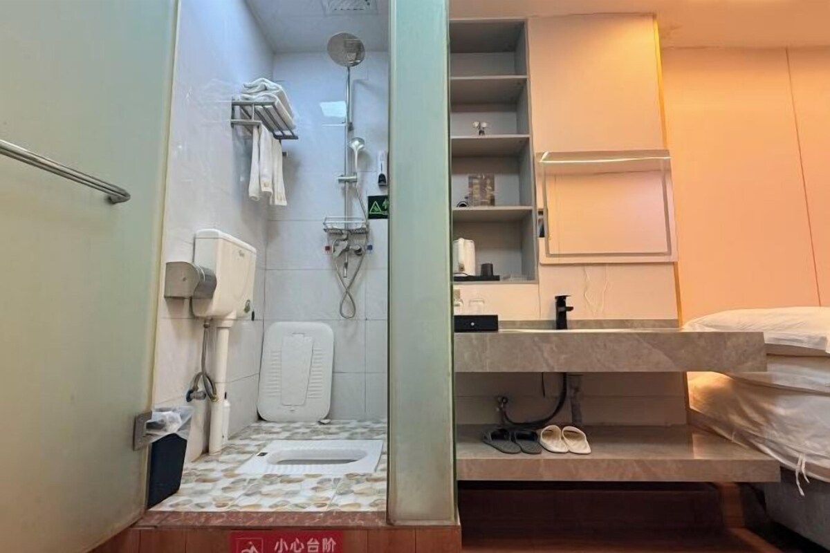 A compact bathroom with a shower, toilet, and sink.