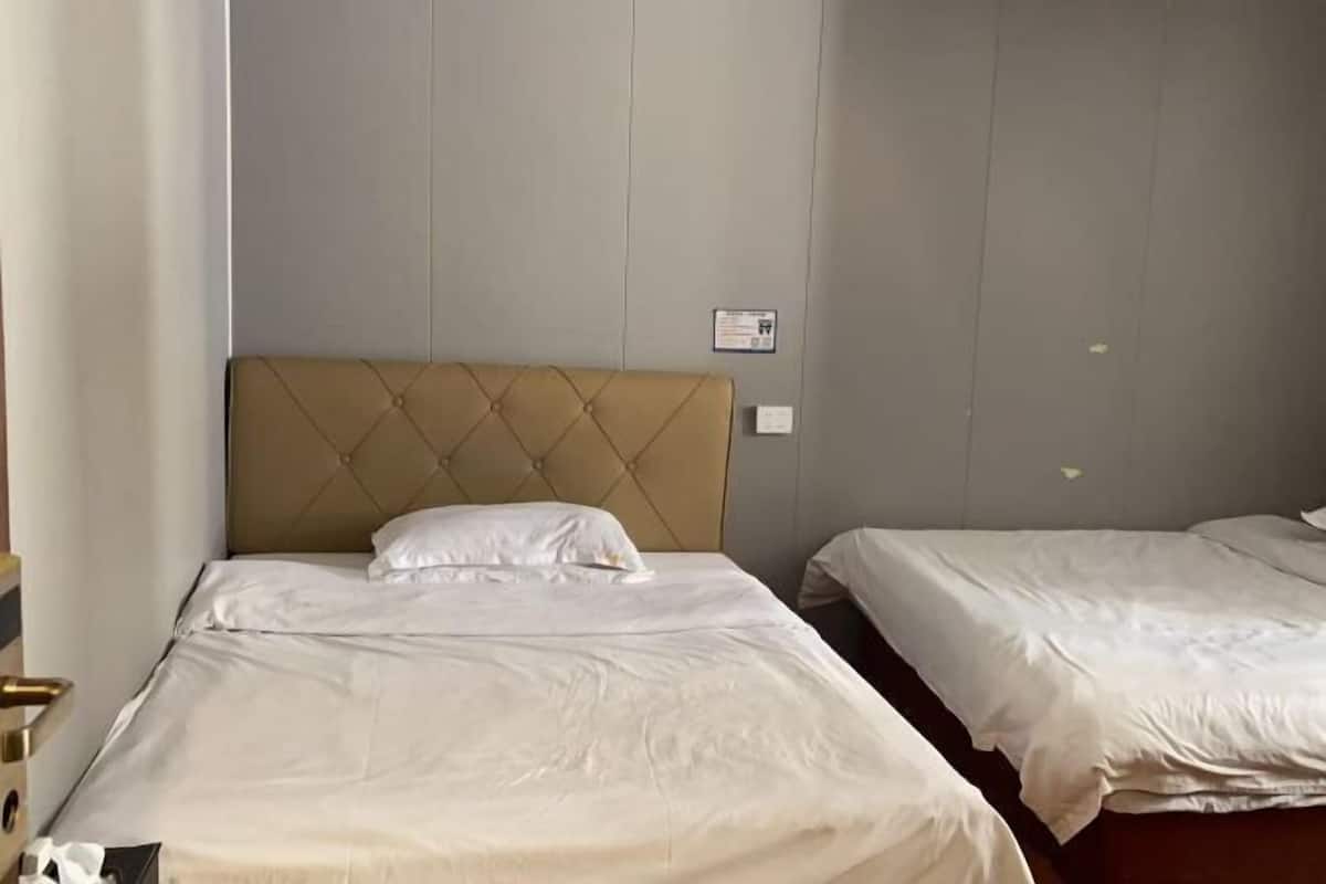Una habitación de hotel con una cama individual, cabecera y una mesita de noche.