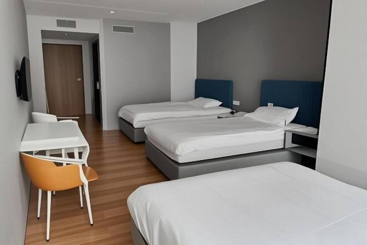 Una habitación de hotel con dos camas, un escritorio y una silla.