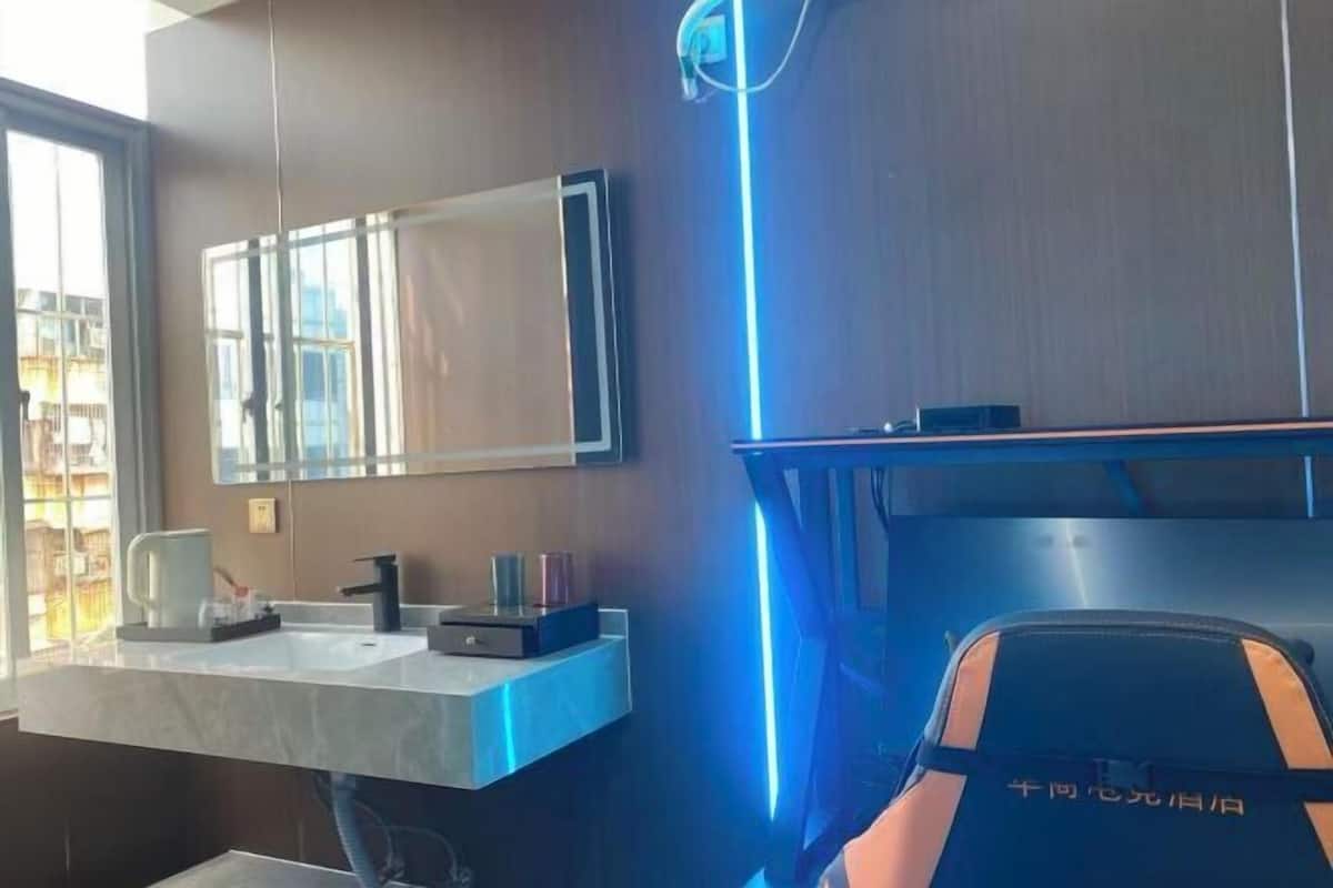 Un baño moderno con un espejo grande, un lavamanos y un perchero para toallas.
