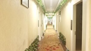 A hallway with a carpet, framed pictures, and a door on the right. - Shenzhen Huashang Hotel (Hongling Subway Station KKmall) (Shenzhen)