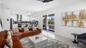 A modern living room with a brown sofa, a marble coffee table, and a large abstract painting on the wall.