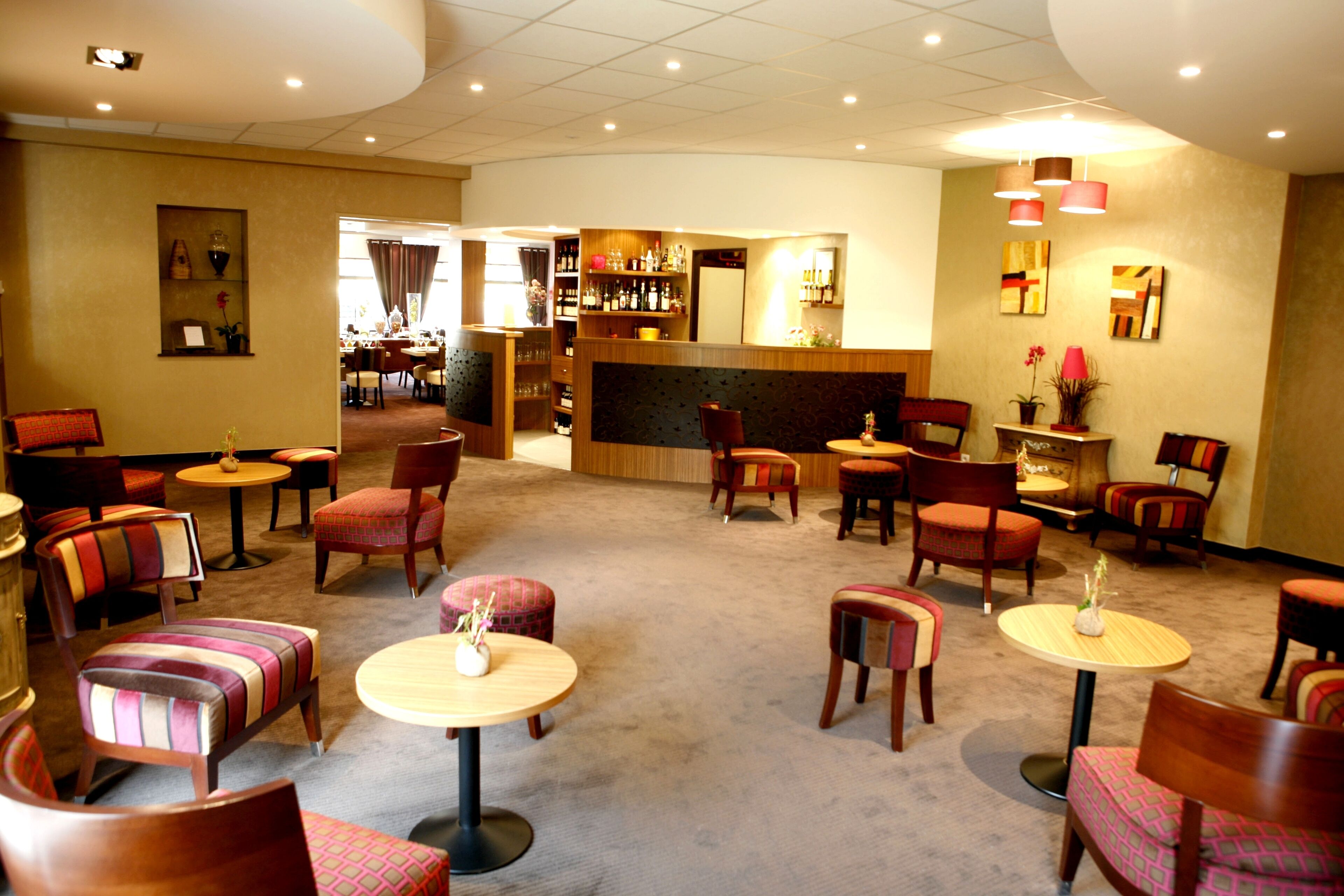 Un hall d’hôtel doté de plusieurs espaces salon, d’un bar et d’un comptoir d’accueil.