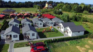Un quartier résidentiel avec plusieurs maisons, une aire de jeux et une église en arrière-plan.