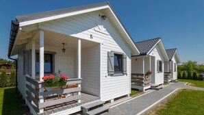 Une rangée de cabanes blanches, chacune dotée d’une porte numérotée, un porche abrité et un chemin menant à l’entrée.