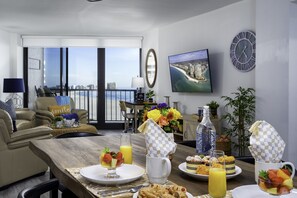Enjoy a meal in the dining area with a city view, featuring a sofa, dining table, and TV.