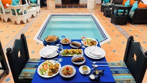 A dining area with a pool table, various dishes, and seating arrangements. - Riad Zarka (Marrakech)
