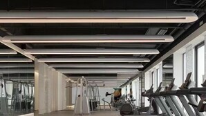 Una sala de gimnàstica moderna amb equip d'exercici i grans finestres.