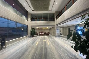 A spacious lobby with a marble floor, a reception desk, and a large window. - Yanfu Hotel (Lianjiang)