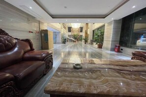 A hotel lobby with a marble reception desk, leather seating, and a view of the interior. - Yanfu Hotel (Lianjiang)