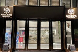 The entrance to Yanfu Hotel with a modern design, featuring a large glass door and illuminated signage. - Yanfu Hotel (Lianjiang)