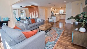 A spacious living area with a grey sofa, wooden coffee table, and a patterned rug. - Emerald Dream, Oceanside House in Emerald Isle, NC (Emerald Isle)